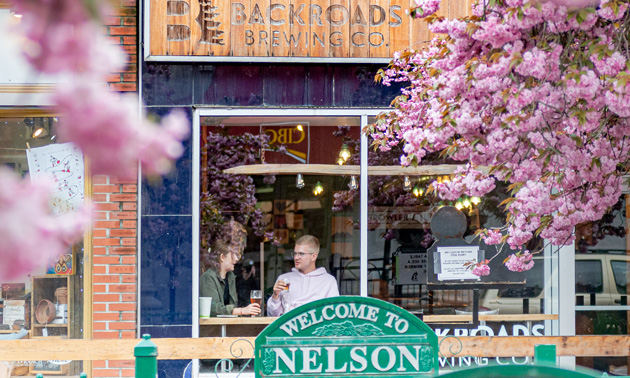 Exterior shot of the Backroads Brewing Company, pink blossom trees in foreground. 
