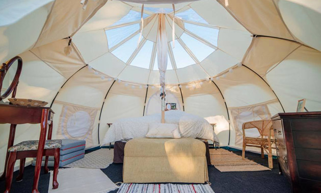 Interior of glamping tent showing bed and furniture. 
