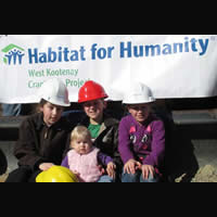 Parents David and Coreena Berry hold the Habitat for Humanity banner while children (left to right) Hanna, 11, Jordan, 8, Alysha, 10, and Samantha, 16 months, show off their hardhats.