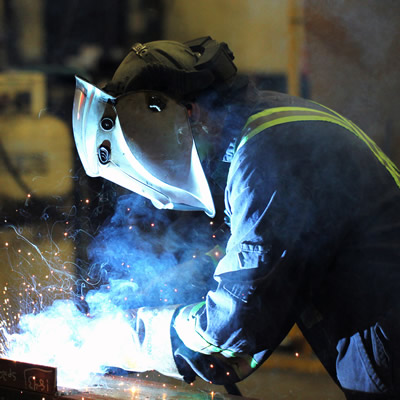 A Unifab tradesman wears protective gear to meet welding safety standards.