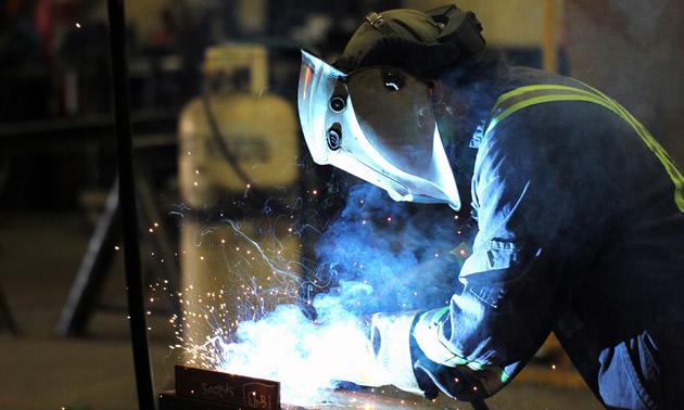 A Unifab tradesman wears protective gear to meet welding safety standards.