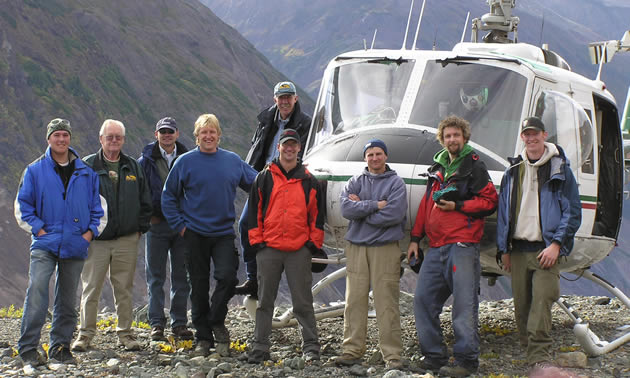 Mountains and a helicopter backdrop the Eagle Plains team at Copper Canyon, 2011