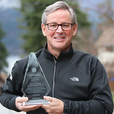 Picture of Bob Falle holding the Lifetime Achievement Award from the Canadian Ski Council. 