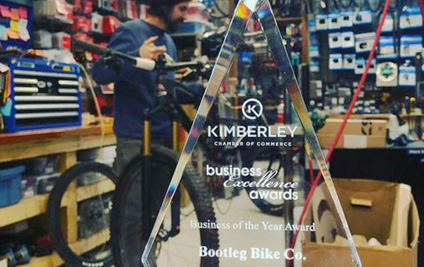 Kimberley Business Excellence award in foreground, tech working on bike in background. 