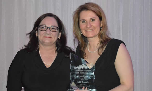 Maureen Foxworthy of the Cranbrook Banking Association presents Heidi Romich with the Business Person of Year Award.