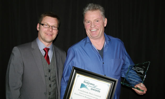 Murray Shellborn (left) of Koocanusa Publications/Kootenay Business magazine presents Con Murphy of Cranbrook Pest Control with the 2018 Business-to-Business excellence award.
