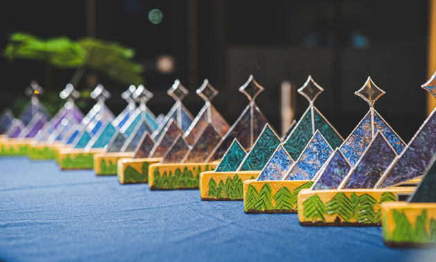 Row of Business Awards, with stained glass star-shaped tops and wooden bases. 