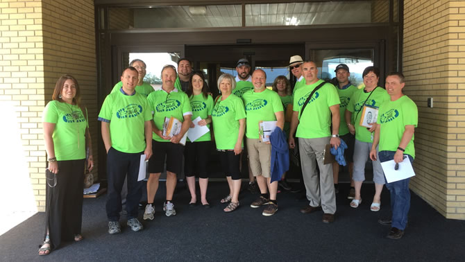 Group of Business Walk members, dressed in bright green t-shirts, heading out to local businesses. 