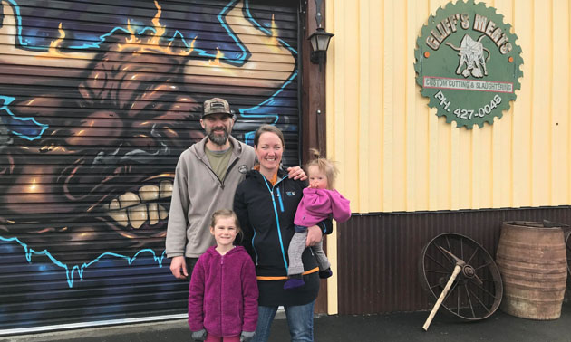 Trevor and Jessica Shulist and family standing in front of their business. 