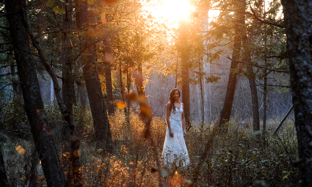 Young woman in a long white dress, in an autumn woodland