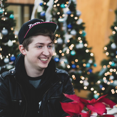 Andrew Crozier in front of Christmas trees. 