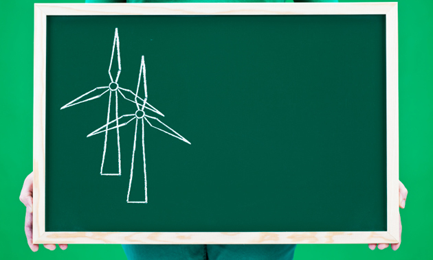 Someone holds a chalkboard which fills most of the screen. On it are sketched two windmills.
