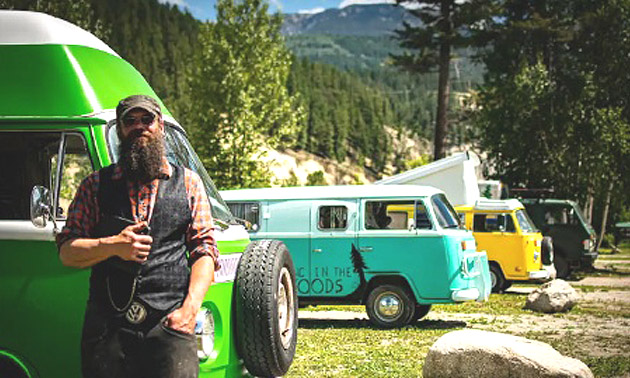 Jeremiah Woods standing in front of row of VW vans. 