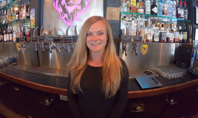 Carly Hadfield stands before the bar at the Lion's Head Smoke & Brew Pub in Castlegar, B.C., where she is the co-owner and vice-president