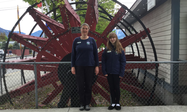 Cedra Eichenauer and Melissa Johnson of the Nakusp and District Chamber of Commerce stand beside the decorative paddlwheel outside the chamber office