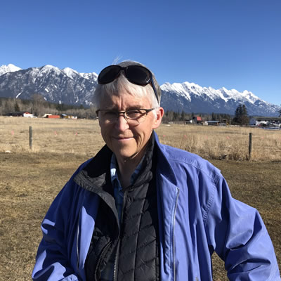 Jan Skiber, posing in front of distant mountains. 