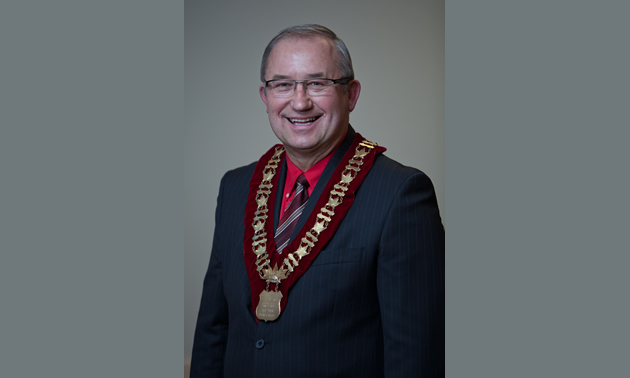 a balding man with a suit and a medal around his neck