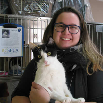 Christy King, the manager of the East Kootenay branch of the B.C. SPCA, cuddles a pretty, black-and-white cat.