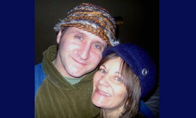 A couple wearing knit hats smile at the camera.