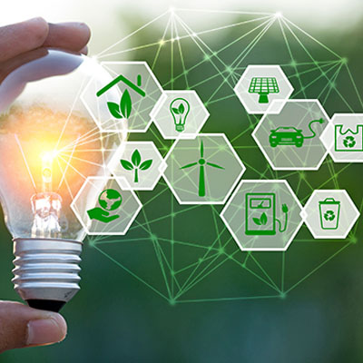 Image of hand holding a lightbulb between thumb and forefinger, with clean energy icons surrounding it. 