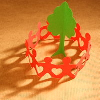 A circle of red paper chain men around a green paper tree.