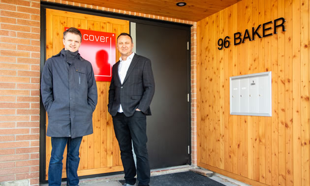 Two men are standing in front of an exterior door to a building. They are Rob Stacey (L) and Lukas Armstrong, principals of Cover Architecture.