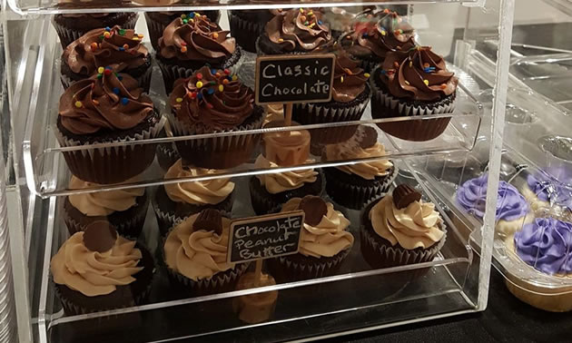 Rows of cupcakes in a clear container. 