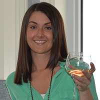 Smiling Danielle Cardozo with a glass of white wine