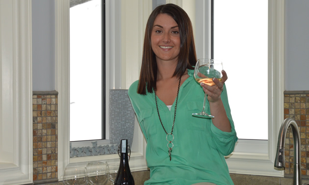 Smiling Danielle Cardozo with a glass of white wine