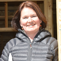 Smiling woman stands in the doorway of a building under construction