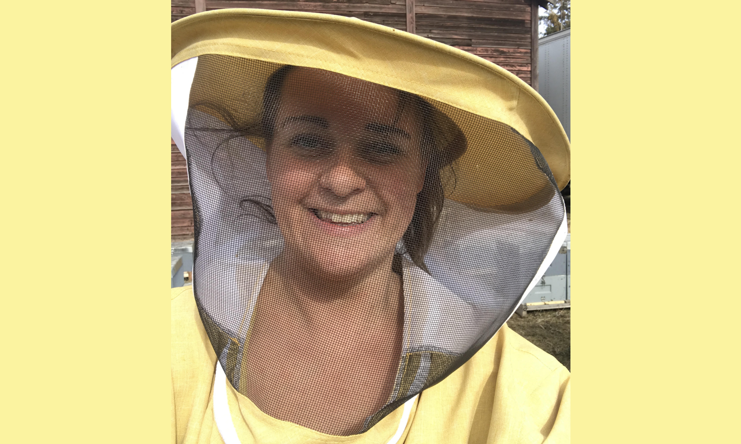 Deirdre Howard wearing a yellow beekeepers suit