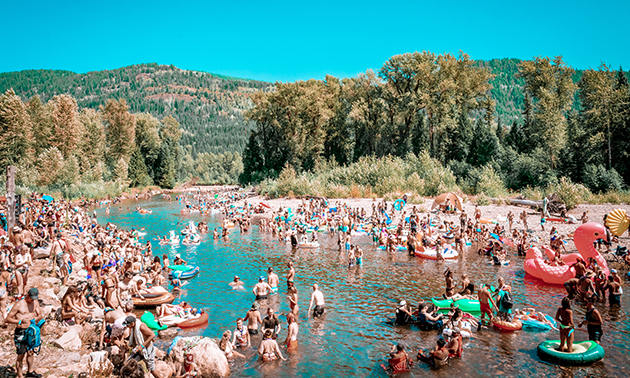 View of Salmo River full with beach goers. 