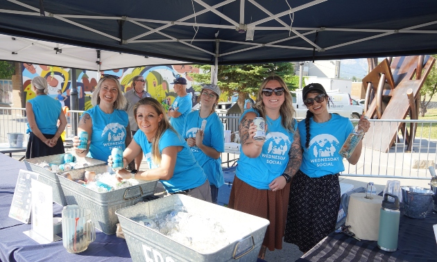 people in blue tshirts with water bottles at a vendor booth