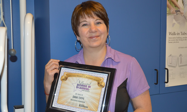 Woman holding a framed certificate saying 
