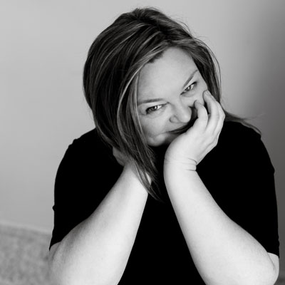 Dana Sproule, posed with hands up by face, B&W photo. 