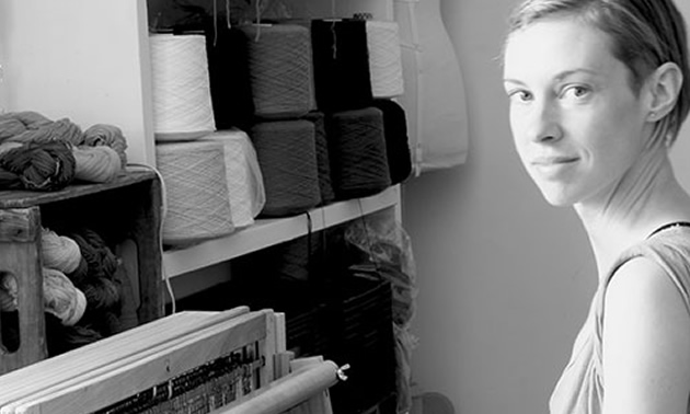 Dani Ortman, fibre artist, sitting at her loom. 