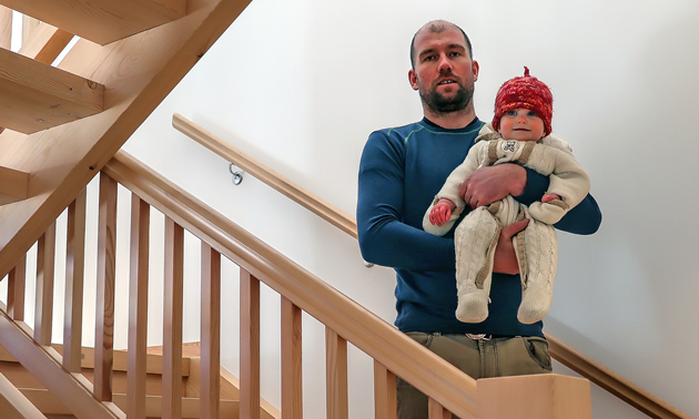 A Madden Timber Construction interior staircase is the backdrop for company owner David Madden and his beautiful baby.