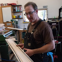 Sheldon DeCosse displays the Maple Rider balance bikes he builds on a workshop table.