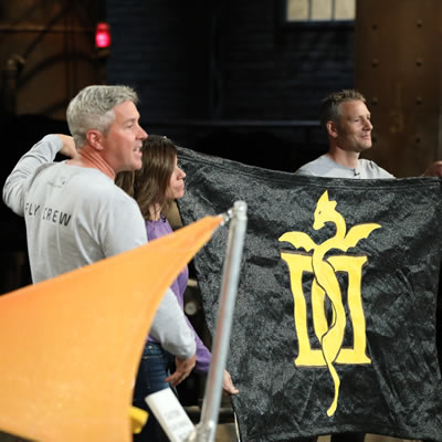 Brydon Roe, Anne Murphy and Graham Harper are holding a black shade with an image of a dragon on it on Dragons’ Den on October 17.
