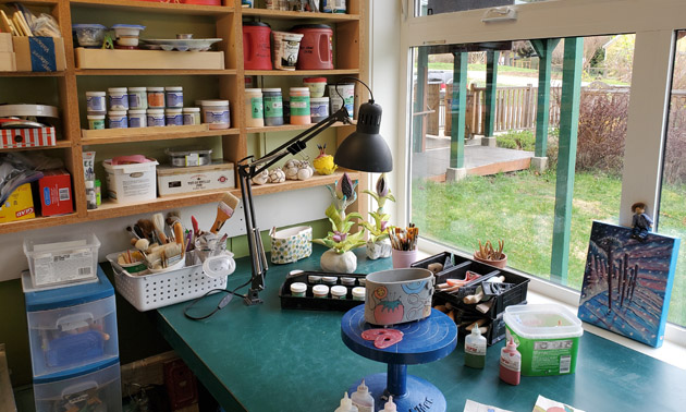 Interior of Dupas Design workspace showing shelves full of clay and paint. 