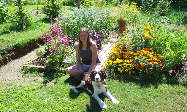 Virginia Rasch sitting in garden with dog. 