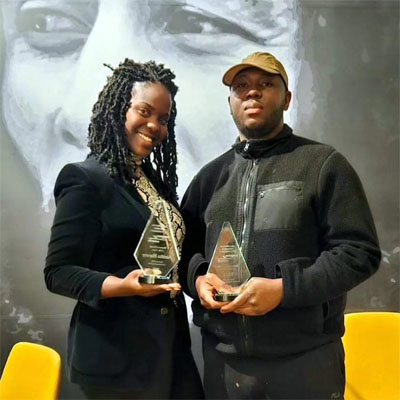 Aleitha Harvey and partner holding Business Excellence awards. 