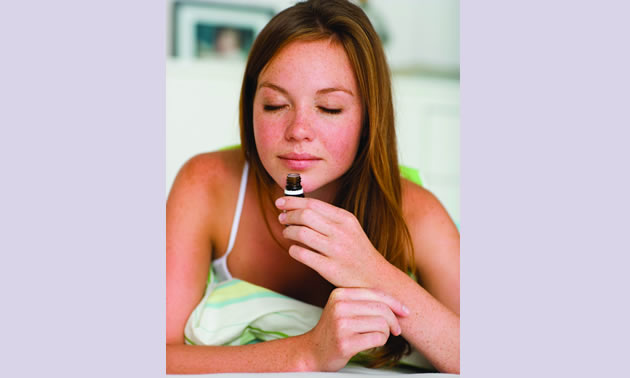 Photo of a girl smelling essential oil sample