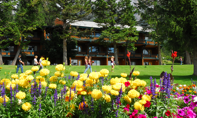Flowers and lawn in foreground with Fairmont Hot Springs Resort Hotel in the background