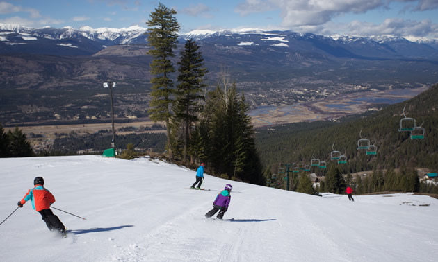 People skiing down a hill at Fairmont Hot Springs Resort. 