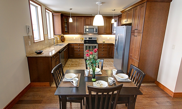 A table is in the front of an open kitchen.