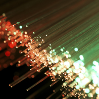 A bundle of fibre-optic cables are lit in green and red.