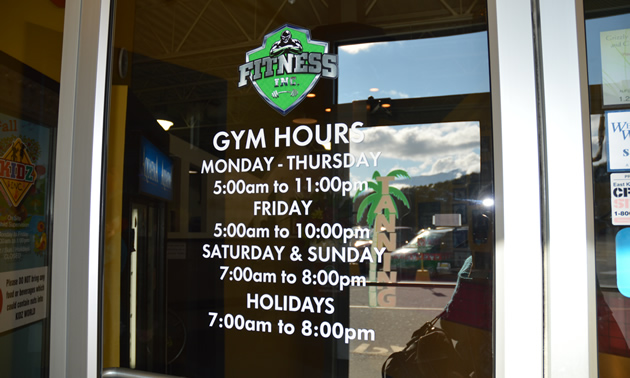 Glass door bearing the Fitness Inc. logo and hours of operation