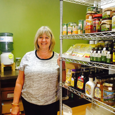 Co-owner Leanna Spring of From the Ground Up in Cranbrook stands next to a shelf full of health foods.