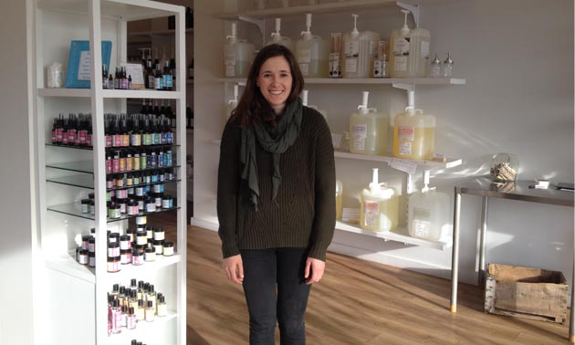 Jill Bentley-Lobban is standing in her store with bulk personal care products behind her.